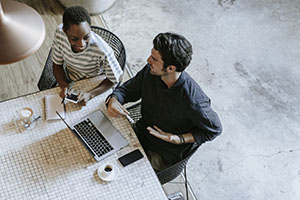 Colleagues discussing their work on a laptop